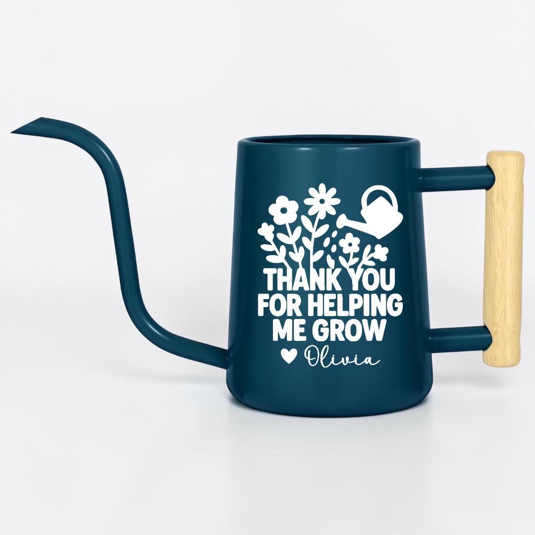 Navy blue metal gooseneck watering can with wood handle. The words 'thank you for helping me grow' with a floral design and small watering can is on the side of the watering can in white and the name 'Olivia' is written under the design with a small heart next to the name.
