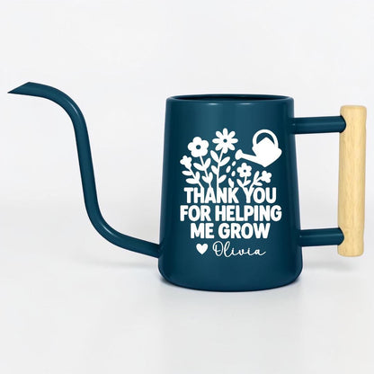 Navy blue metal gooseneck watering can with wood handle. The words 'thank you for helping me grow' with a floral design and small watering can is on the side of the watering can in white and the name 'Olivia' is written under the design with a small heart next to the name.