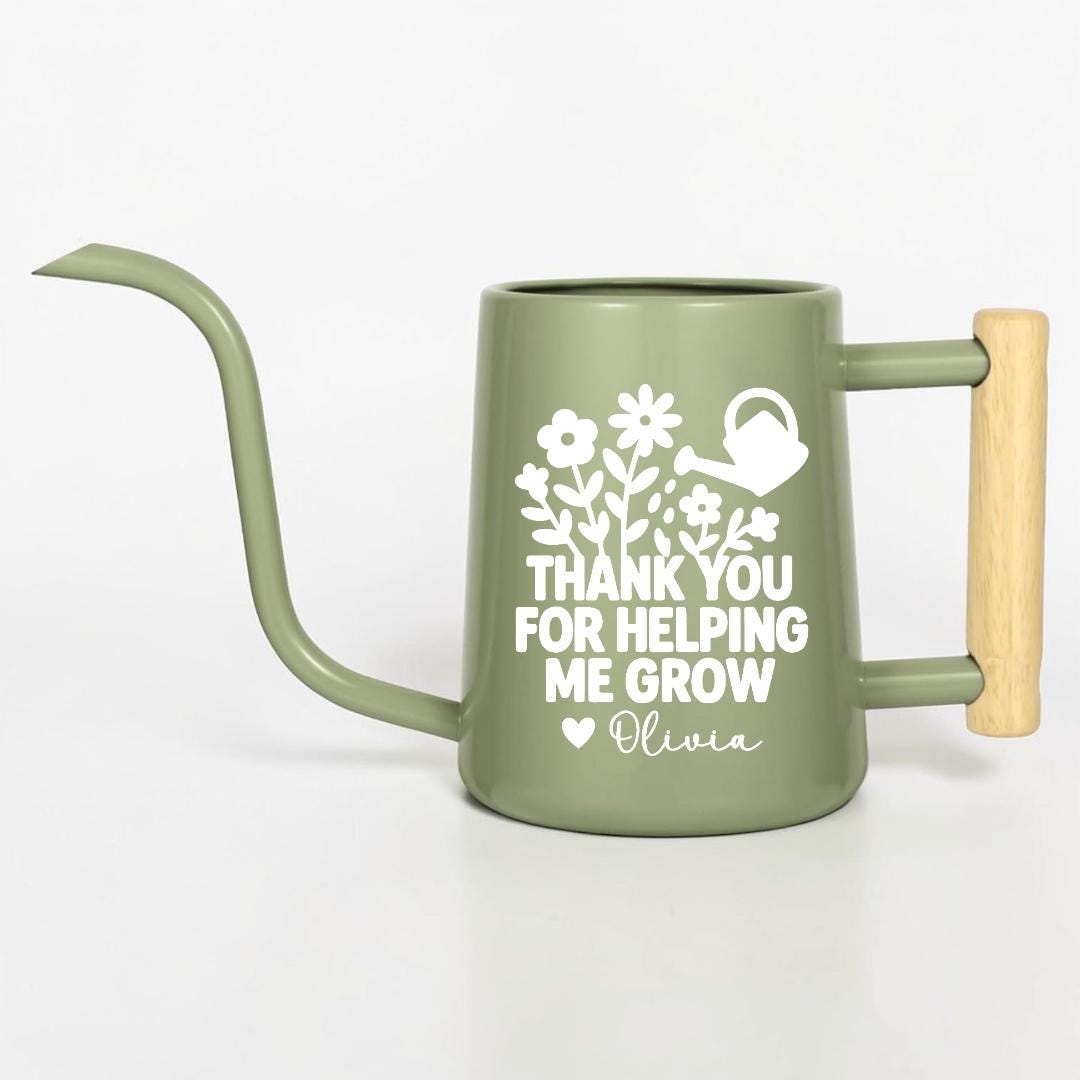 Sage green metal watering can with a long spout and wooden handle. The can features a white floral design and the text "THANK YOU FOR HELPING ME GROW" with a heart and the name "Olivia".