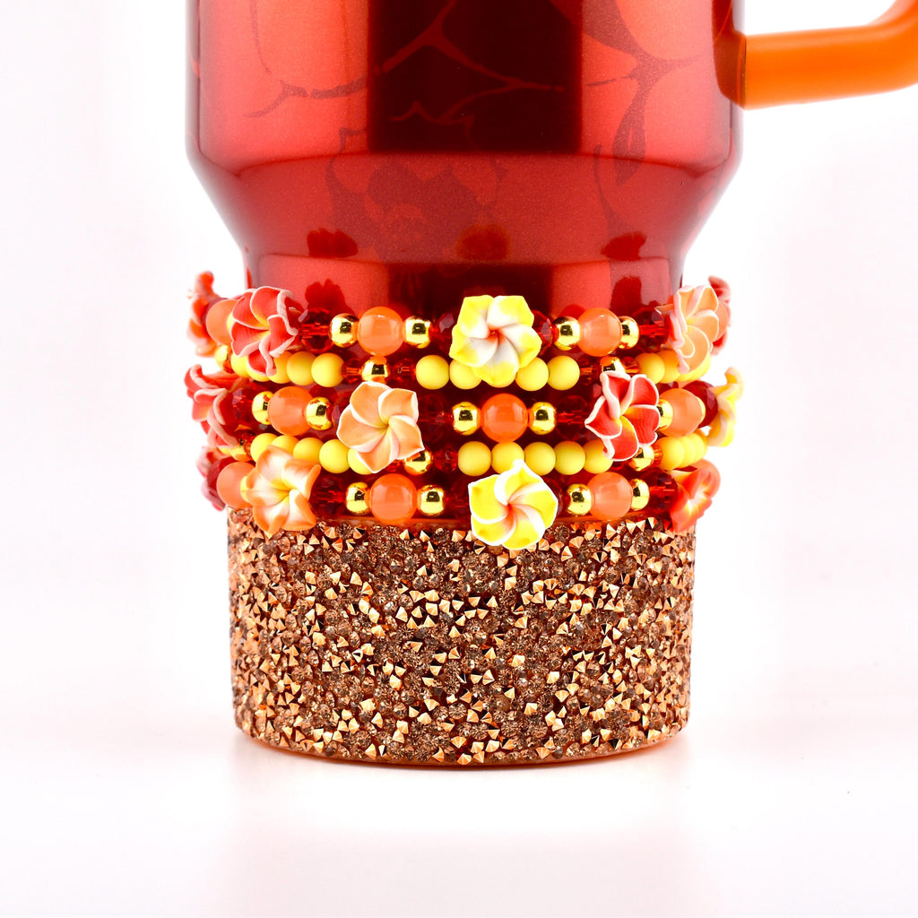 A set of five beaded bracelets with hibiscus flowers and gold and yellow beaded accents.
