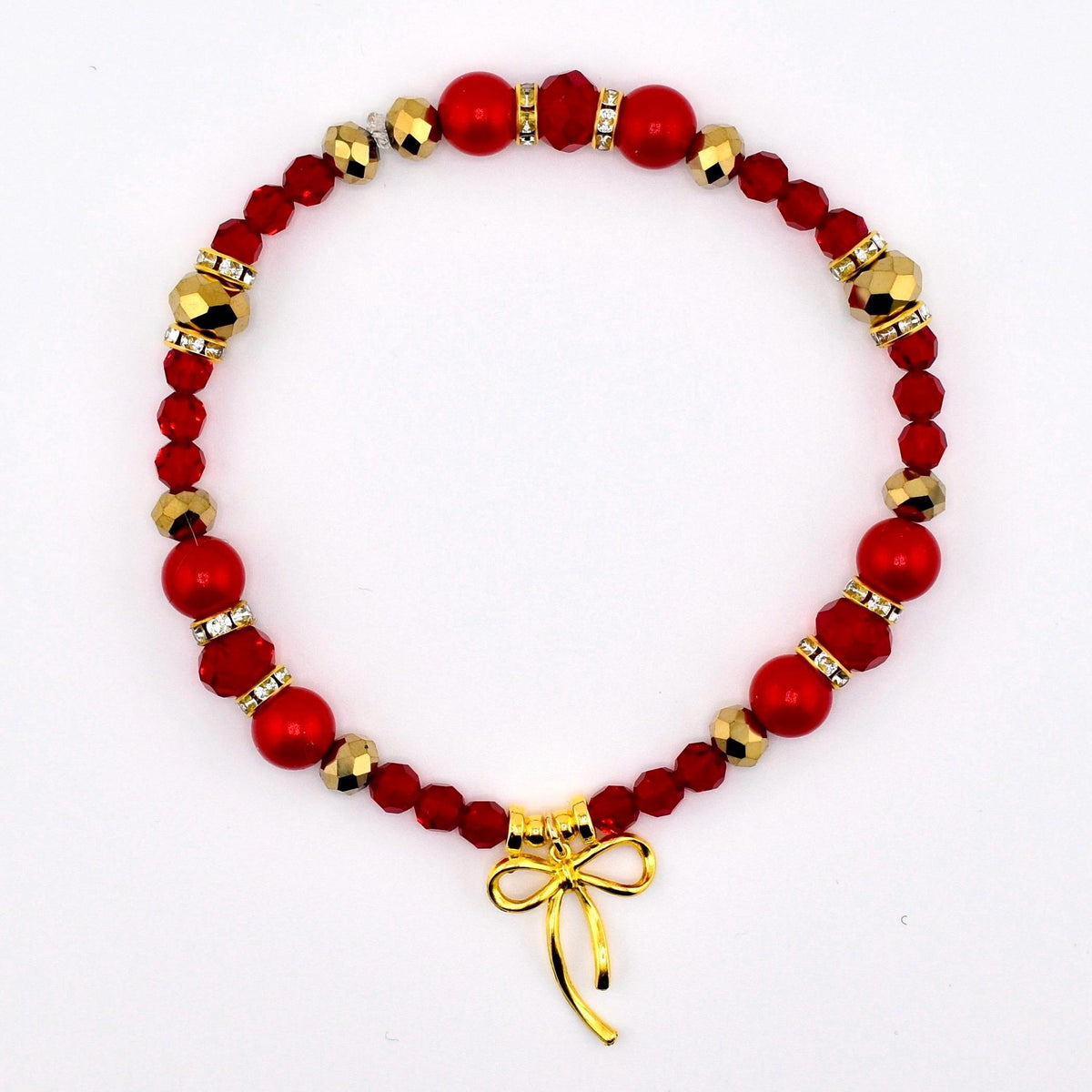 A red beaded bracelet with gold accents and a gold bow charm. The bracelet features a mix of red beads, including round and faceted shapes, interspersed with gold-colored beads and small crystal accents. The gold bow charm hangs at the bottom.