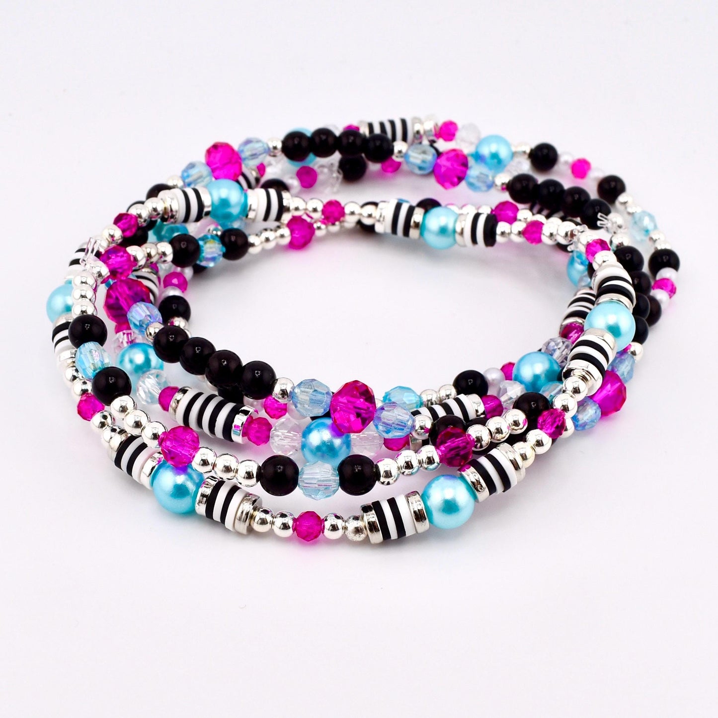A set of four beaded bracelets in a spiral arrangement. The bracelets feature a mix of black, pink, light blue, and clear beads, along with silver and black striped accents. The beads are strung on a silver wire.