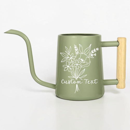 A sage green metal watering can with a long, slender spout and a light-colored wooden handle. The body features a white line-art illustration of a floral bouquet and the words Custom Text printed in a cursive script font.