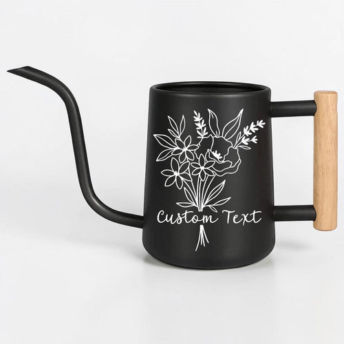 A matte black watering can with a long, slender spout and a light-colored wooden handle. The body features a white line-art illustration of a floral bouquet and the text Custom Text printed in a cursive script font on the front.