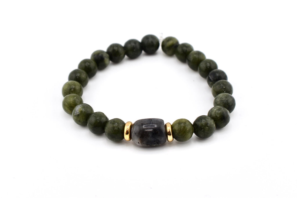 A beaded bracelet featuring olive green round beads and a central dark gray, rectangular bead. Gold-colored spacers flank the central bead. The bracelet is on a white background.