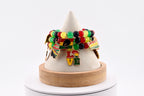 A beaded bracelet with red, yellow, green, and black beads. The bracelet has Juneteenth gold charms with the word "LOVE" and other cultural symbols. The bracelet is displayed on a white cone-shaped stand.