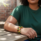 Beaded bracelets with red, yellow, green, and black beads. The bracelet features charms with the colors of the Rastafarian flag, a gold-colored charm with a lion, and charms with the word "LOVE".