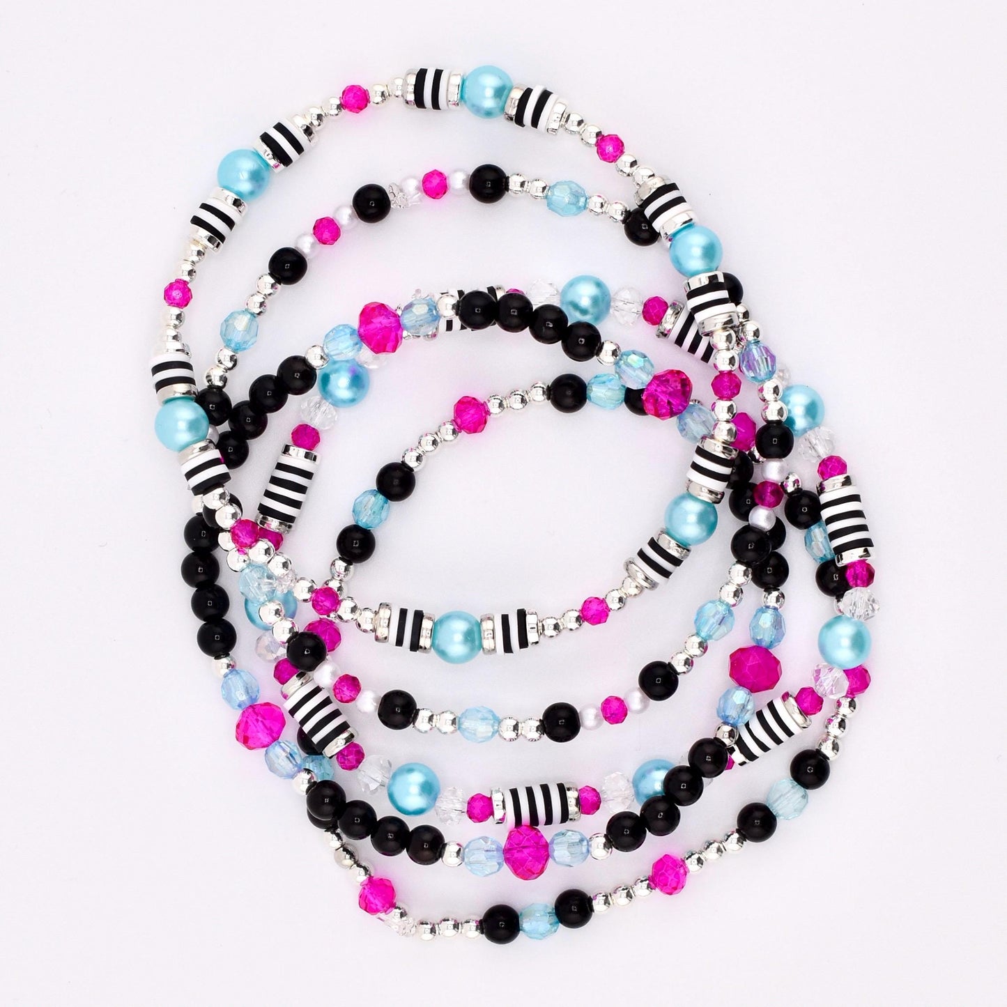 A collection of beaded bracelets in various colors. The bracelets feature black, pink, and light blue beads, along with silver and black striped beads. The bracelets are arranged in a circular pattern against a white background.