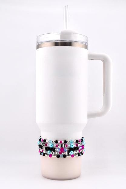White insulated tumbler with a handle and a clear lid, featuring a clear straw. The tumbler is adorned with multiple beaded bracelets in black, pink, blue, and silver. The bracelets are wrapped around the base of the tumbler.
