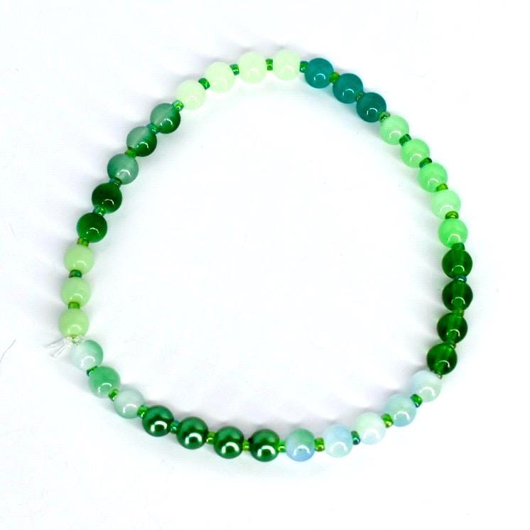 Emerald green bead bracelet – round gemstone stretch design with green accent beads for stylish jewelry stacking.