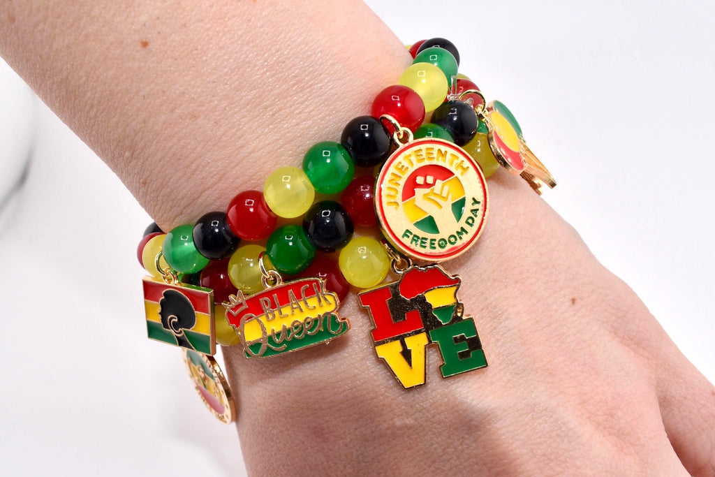 A beaded bracelet with charms in red, yellow, green, and black. The charms include the words "Juneteenth Freedom Day", "Black Queen", and "LOVE", along with other symbols.