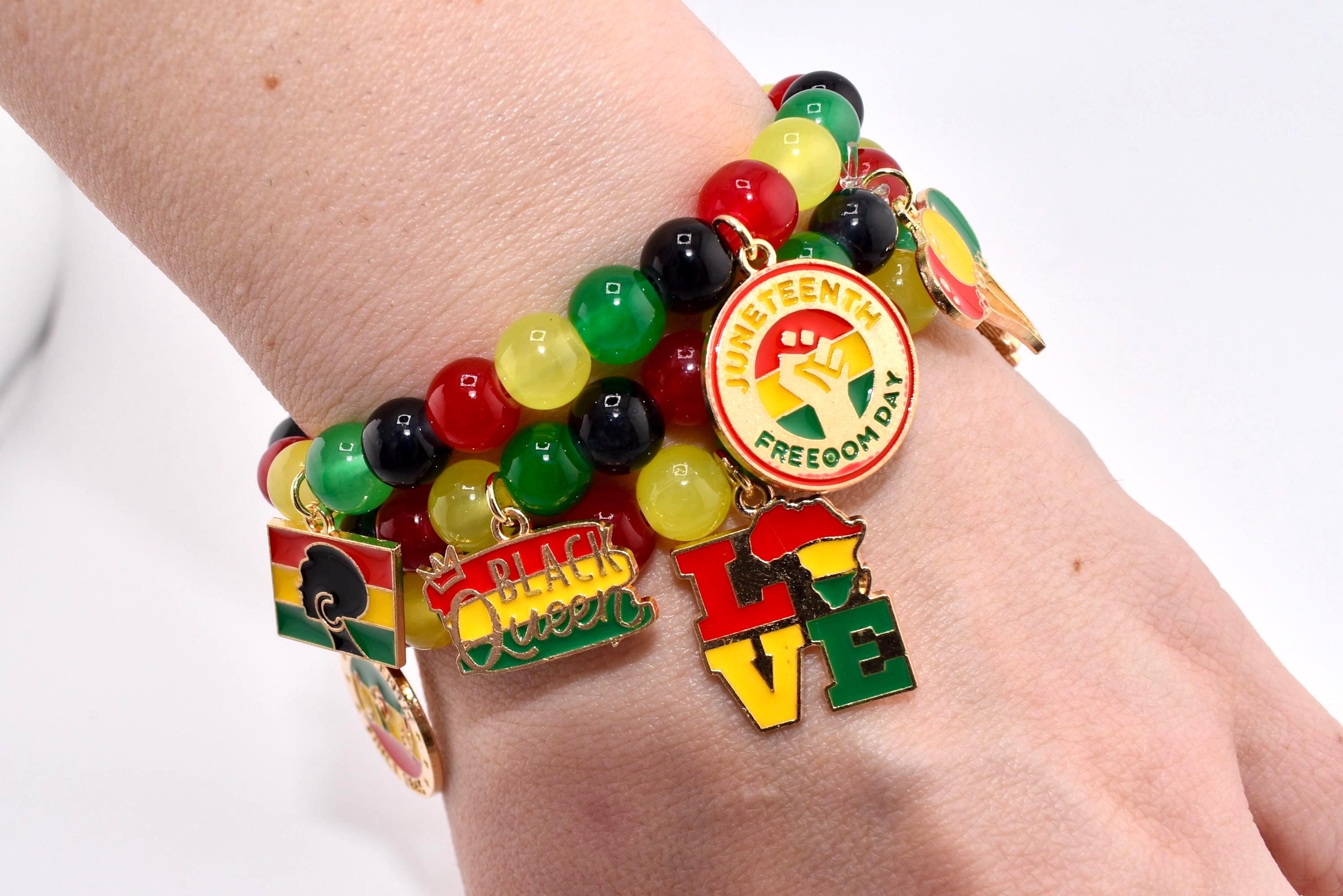 A beaded bracelet with charms in red, yellow, green, and black. The charms include the words "Juneteenth Freedom Day", "Black Queen", and "LOVE", along with other symbols.
