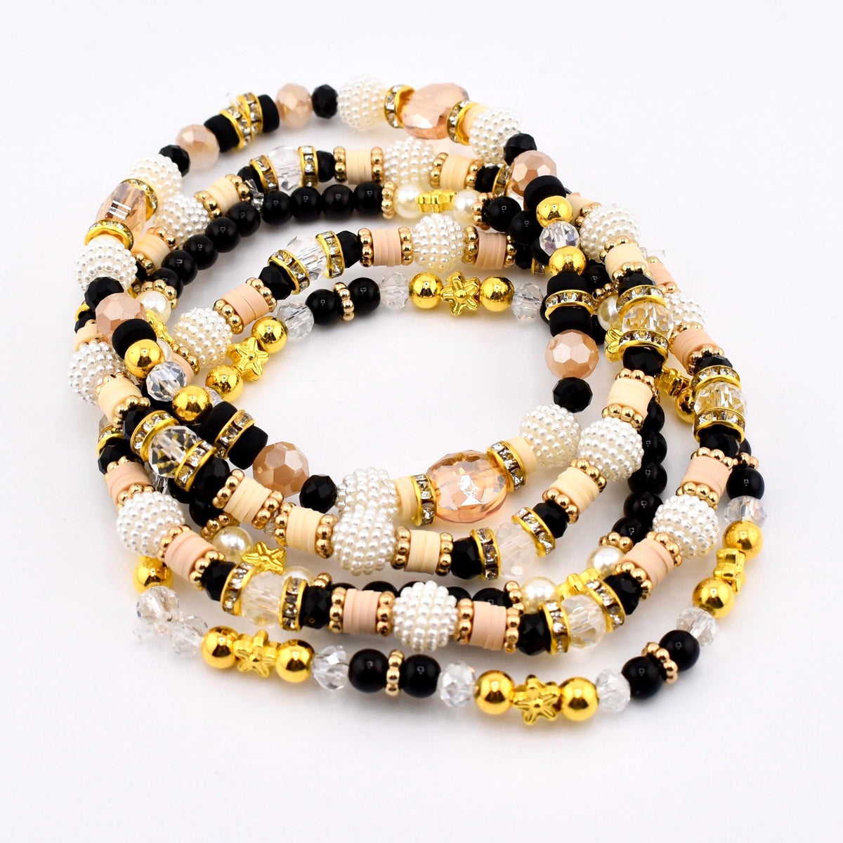 A collection of beaded waist beads in various colors. The beads include black, white, gold, peach, and clear. The beads are strung together to create a decorative accessory.