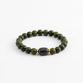 Handmade beaded bracelet with dark green beads and one black stone bead in the center with two gold spacer beads on either side.