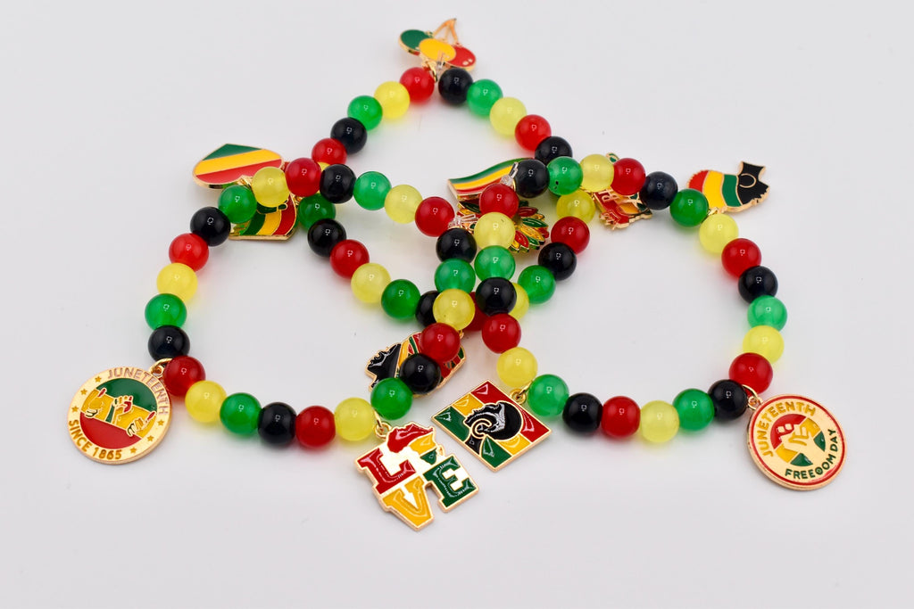 Beaded bracelets in red, yellow, green, and black. Each bracelet features Juneteenth-themed charms and pendants with the word "LOVE" and the phrase "Juneteenth Freedom Day" on them. The bracelets are on a white background.