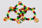 Beaded bracelets in red, yellow, green, and black. Each bracelet features Juneteenth-themed charms and pendants with the word "LOVE" and the phrase "Juneteenth Freedom Day" on them. The bracelets are on a white background.