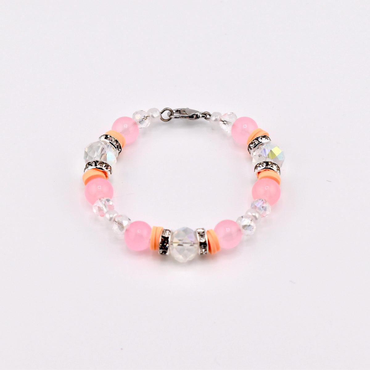 A beaded bracelet featuring pink and clear beads, accented with orange spacers and sparkling crystal elements. The bracelet is secured with a silver-tone clasp, showcasing a delicate and feminine design.