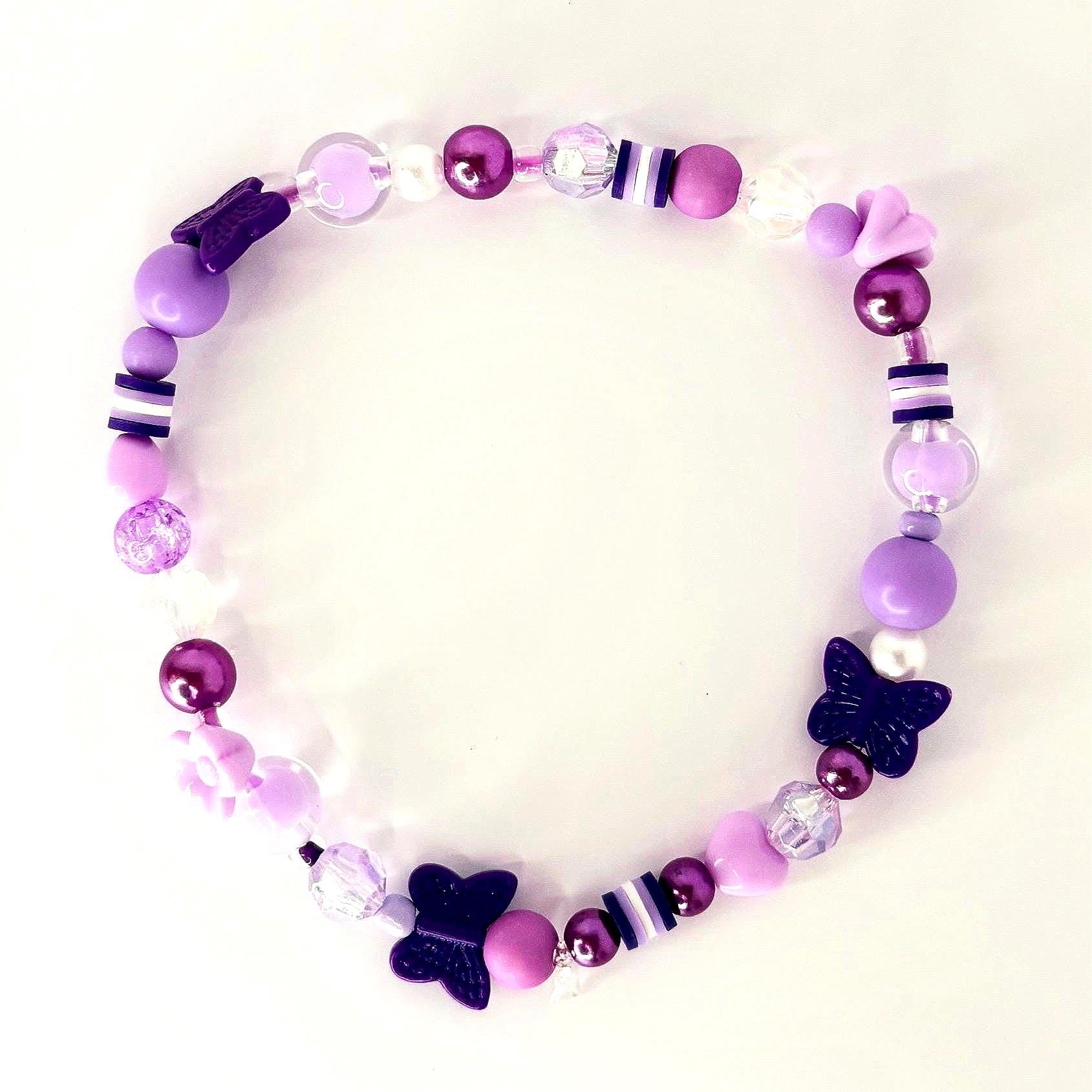 A beaded bracelet featuring a variety of purple beads, including round, heart-shaped, and butterfly-shaped beads. The bracelet has a mix of light and dark purple beads, with some clear and white accents.