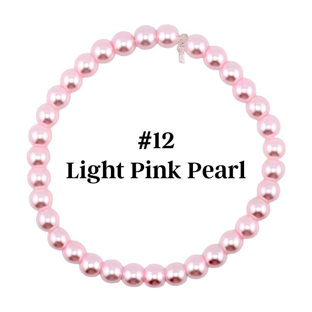 A light pink pearl bracelet. The bracelet is made of round, light pink pearls strung together. The text "#12 Light Pink Pearl" is displayed in the center of the bracelet.