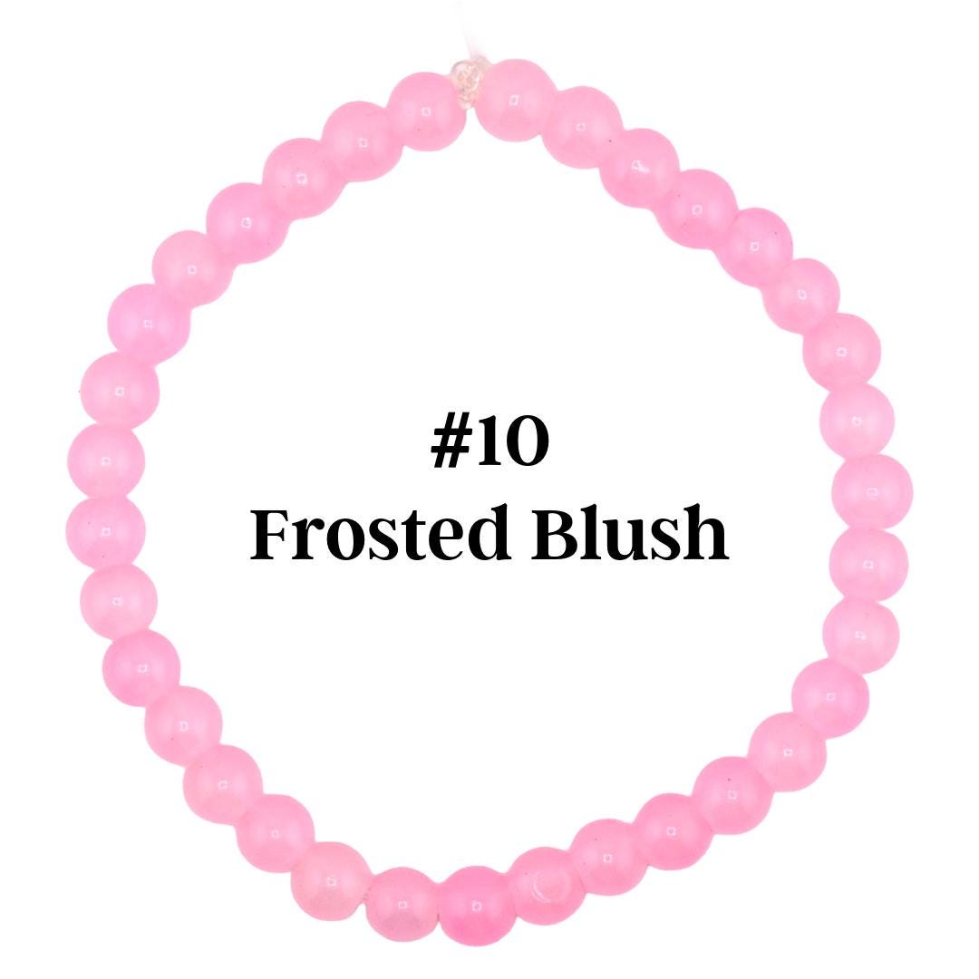 A light pink beaded bracelet with the text "#10 Frosted Blush". The bracelet is made of small, round beads strung together. The beads are a soft, pastel pink color.