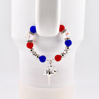 A patriotic bracelet featuring red, white, and blue beads, interspersed with silver-colored beads and star-shaped charms. The bracelet is adorned with a dangling silver star pendant. The beads are approximately 0.5 inches in diameter.