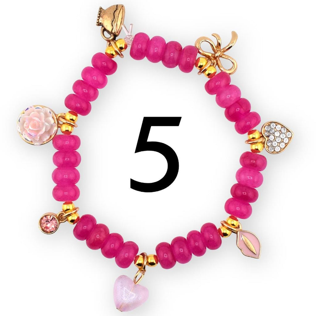 A pink beaded bracelet with gold accents and charms. Charms include a teacup, bow, heart, and a pink leaf. The number 5 is in the center of the bracelet.