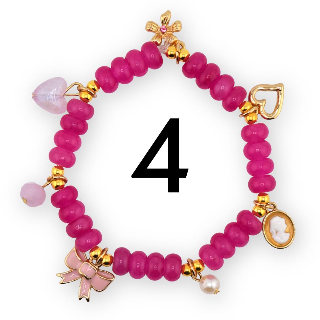 A pink beaded bracelet with gold accents and charms. Charms include a heart, bow, flower, cameo, and pearl. The number "4" is in the center of the bracelet.