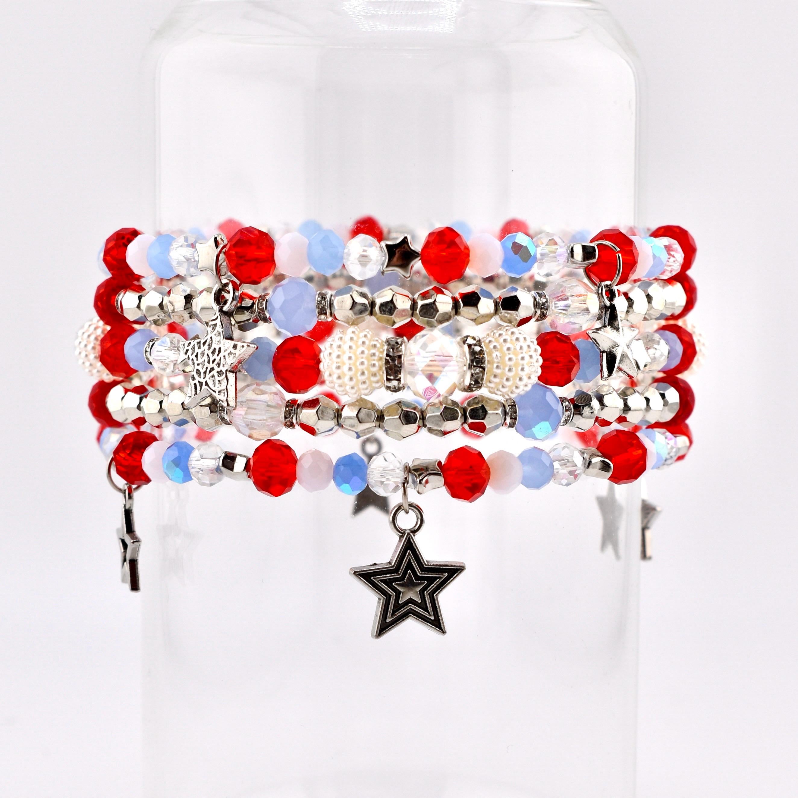 A stack of beaded bracelets in red, white, and blue. The bracelets feature various bead sizes and shapes, including round, faceted, and pearl-like beads. Some bracelets have star-shaped charms.