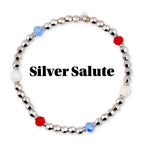 Silver beaded bracelet with faceted silver beads, interspersed with red, white, and blue accent beads. The text "Silver Salute" is displayed in black, bold font.