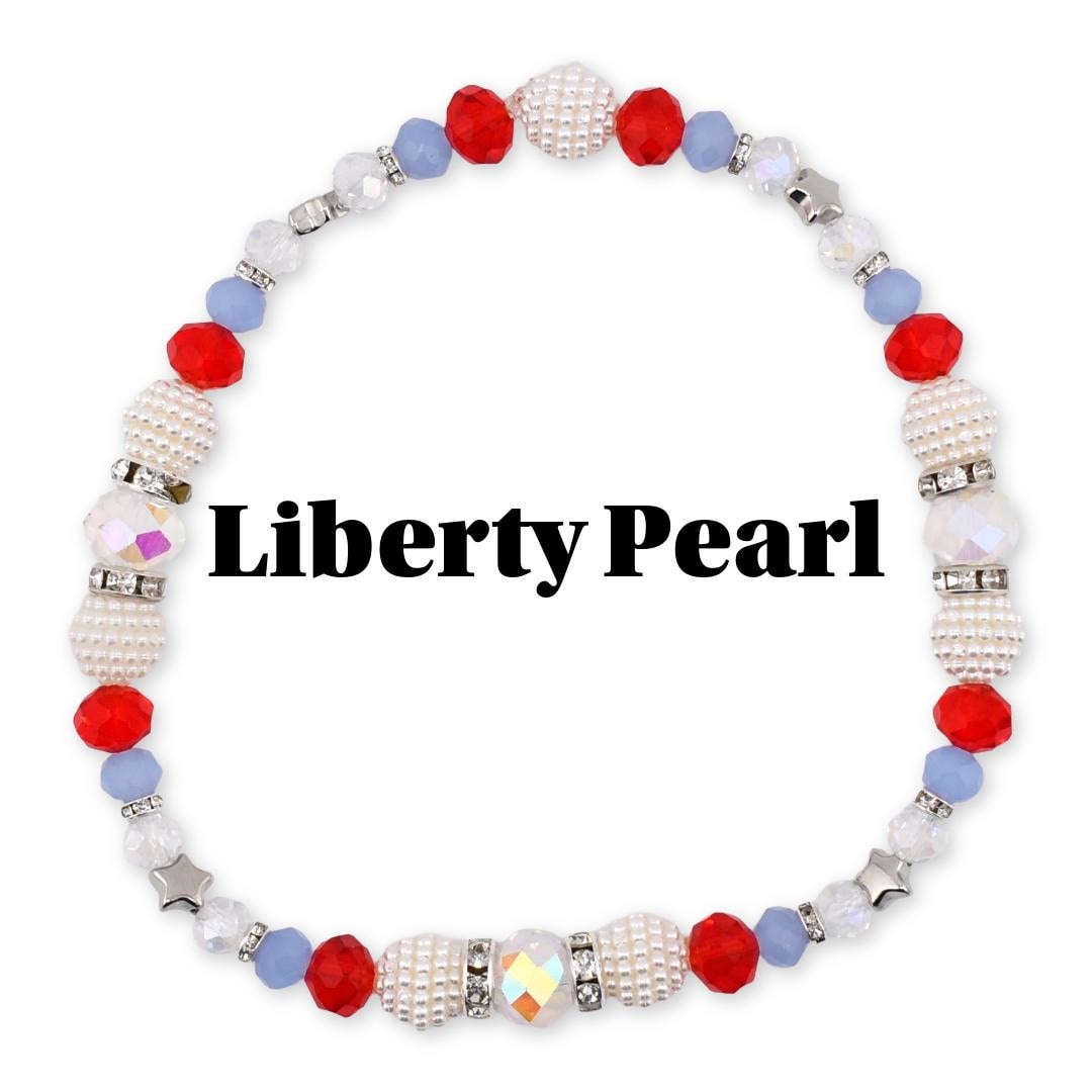 A beaded bracelet with the text "Liberty Pearl". The bracelet features red, white, and blue beads. The beads include round red beads, white pearl-like beads, and light blue beads. Some beads are accented with silver-colored metal and clear crystals.