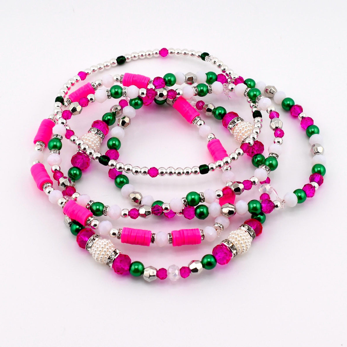 A collection of beaded bracelets in shades of pink, green, white, and silver. The bracelets feature a variety of bead sizes and shapes, including small round beads, cylindrical beads, and larger decorative beads. The bracelets are arranged in a circular pattern.