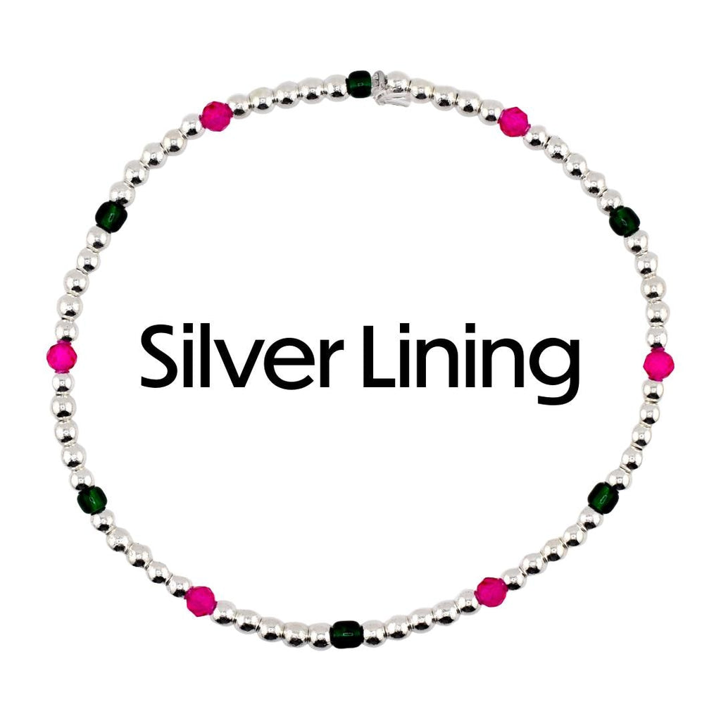 A silver beaded bracelet with alternating pink and green beads. The bracelet is circular and features the text "Silver Lining" in black. The beads are small and evenly spaced.