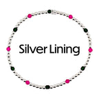 A silver beaded bracelet with alternating pink and green beads. The bracelet is circular and features the text "Silver Lining" in black. The beads are small and evenly spaced.