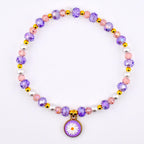 A beaded necklace featuring a daisy pendant. The necklace is composed of purple, pink, and white beads, interspersed with gold-colored accents. The pendant is a small, round charm with a white daisy on a purple background.