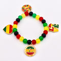 A beaded bracelet with red, yellow, green, and black beads. The bracelet features charms with the words "LOVE", a heart, a sunflower, and a circular charm with the words "Juneteenth Since 1865".