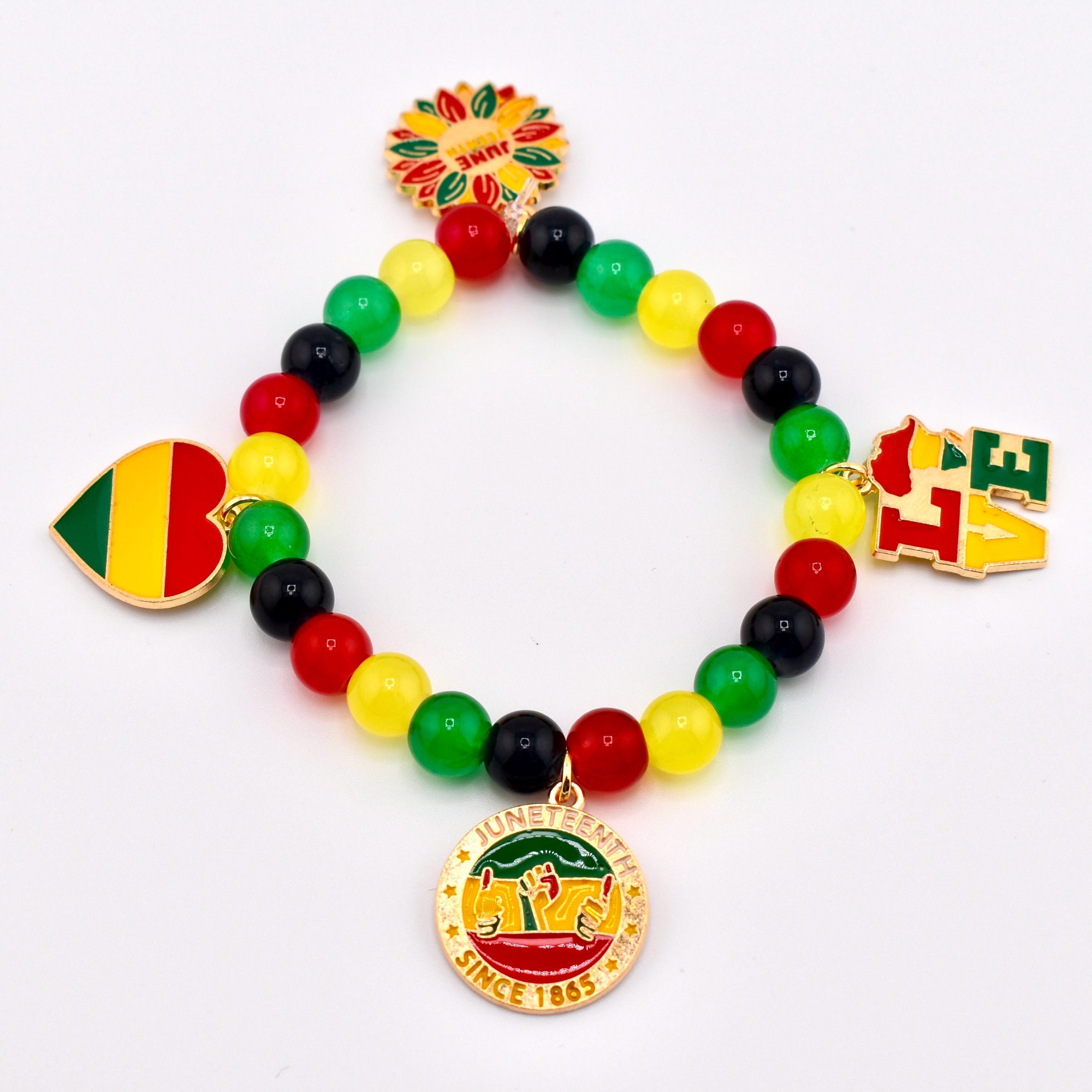 A beaded bracelet with red, yellow, green, and black beads. The bracelet features charms with the words "LOVE", a heart, a sunflower, and a circular charm with the words "Juneteenth Since 1865".