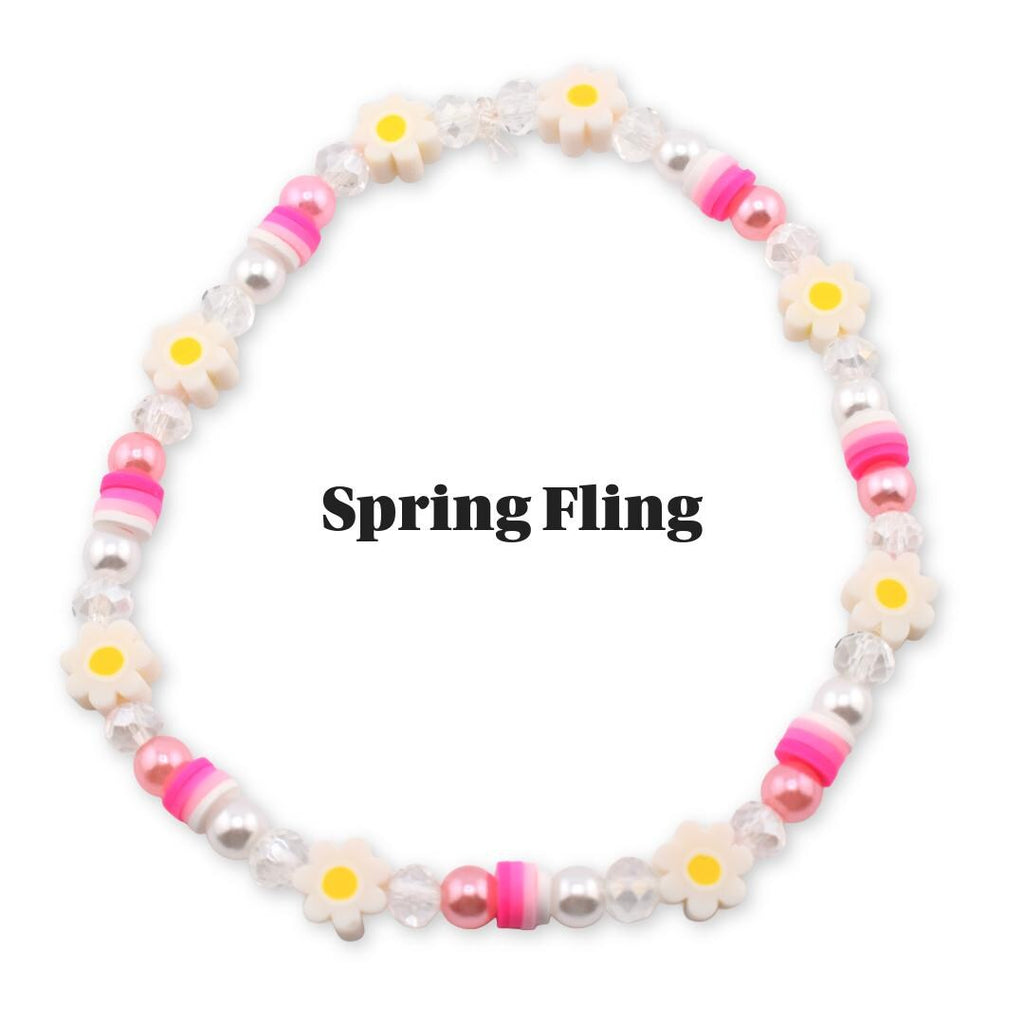 A beaded bracelet with a spring theme. The bracelet features white daisy-shaped beads with yellow centers, pink and white striped beads, and pearl-like beads. The text "Spring Fling" is displayed in the image.