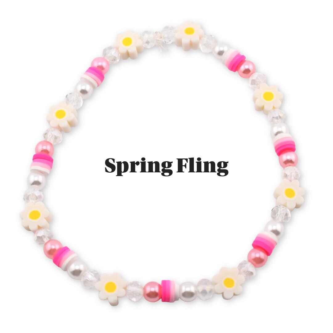 A beaded bracelet with a spring theme. The bracelet features white daisy-shaped beads with yellow centers, pink and white striped beads, and pearl-like beads. The text "Spring Fling" is displayed in the image.