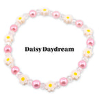 A beaded bracelet featuring pink pearls, clear crystal beads, and daisy-shaped charms with yellow centers. The bracelet has the text "Daisy Daydream" in black.