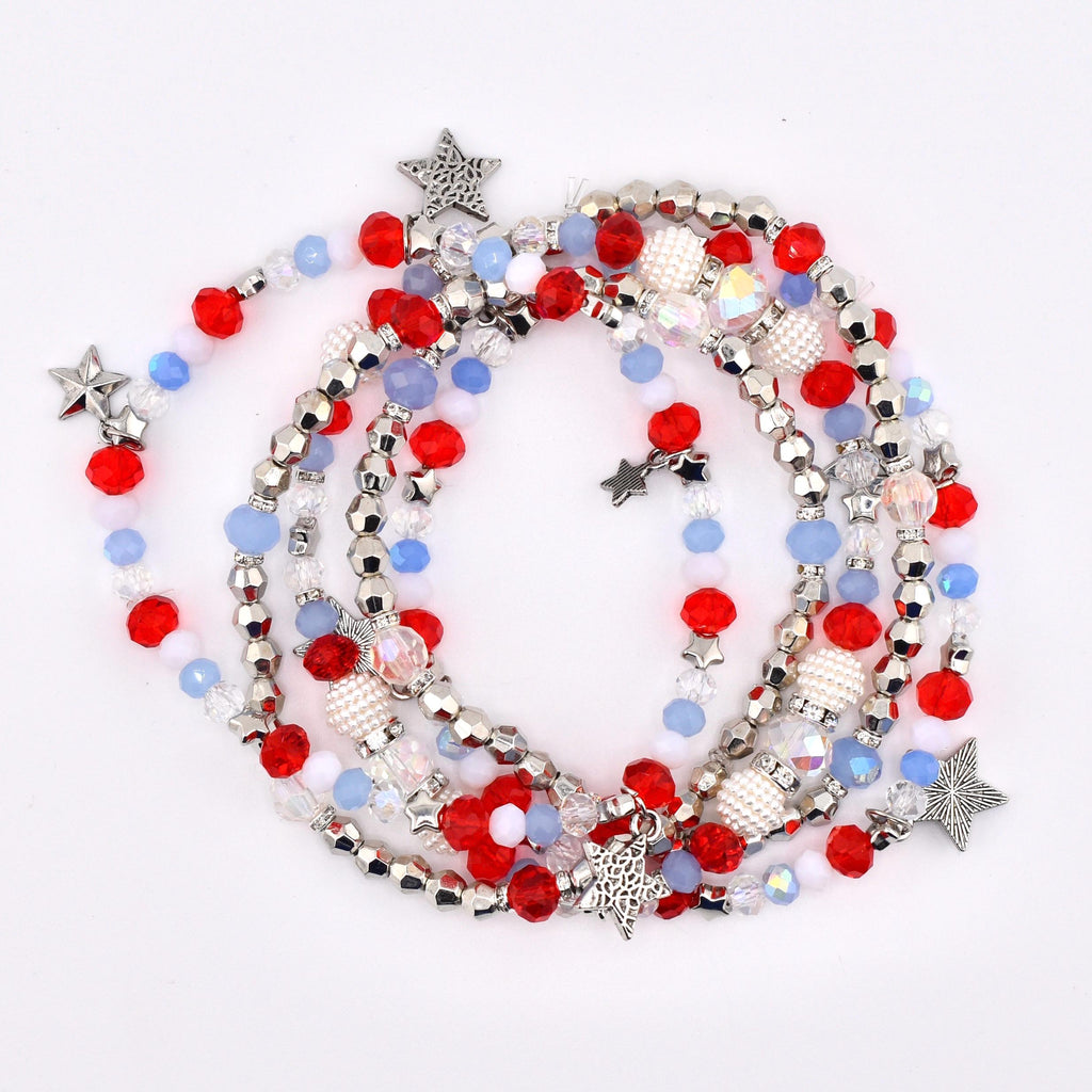 A collection of beaded necklaces with red, white, silver, and blue beads. The necklaces feature star-shaped charms and are arranged in a layered design. The beads are a mix of round and faceted shapes.