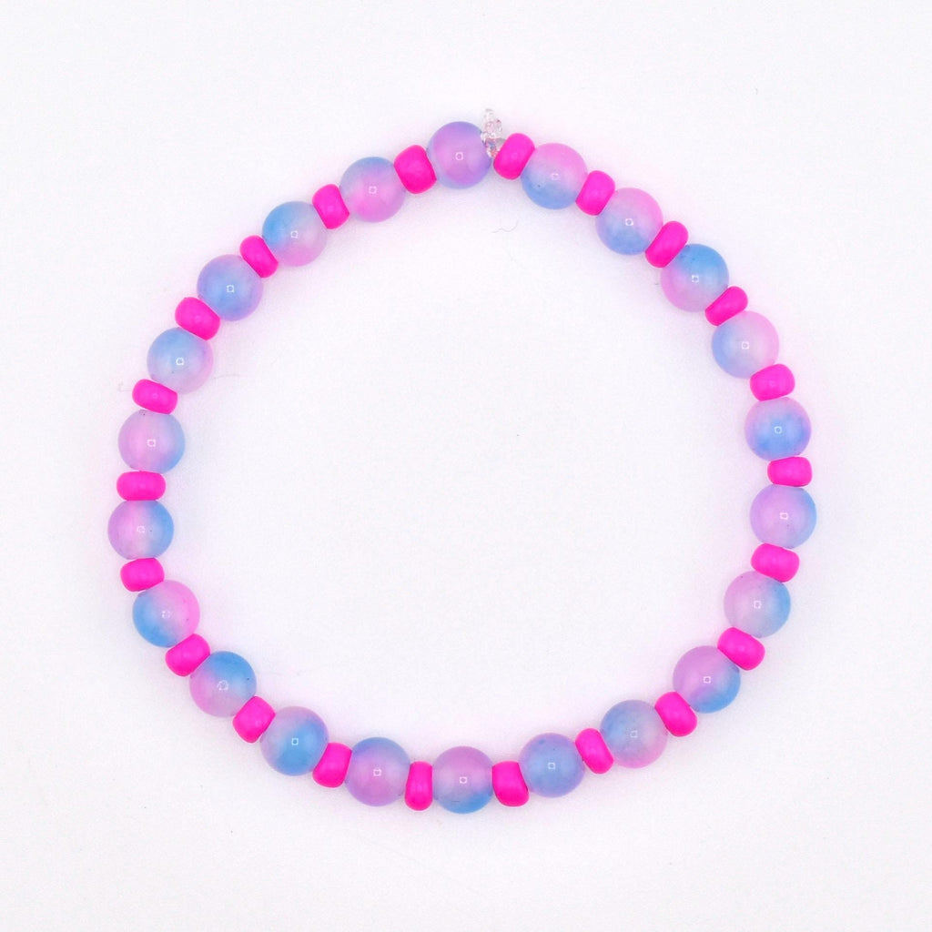 A beaded bracelet featuring alternating pink and blue-purple gradient beads with bright pink spacer beads. The bracelet is strung on a clear elastic cord and is set against a white background.