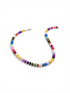 A necklace featuring a continuous strand of small, round, multi-colored gemstone beads in shades of red, orange, yellow, green, blue, purple, pink, and white. The beads are arranged in a vibrant sequence and secured with a silver clasp.