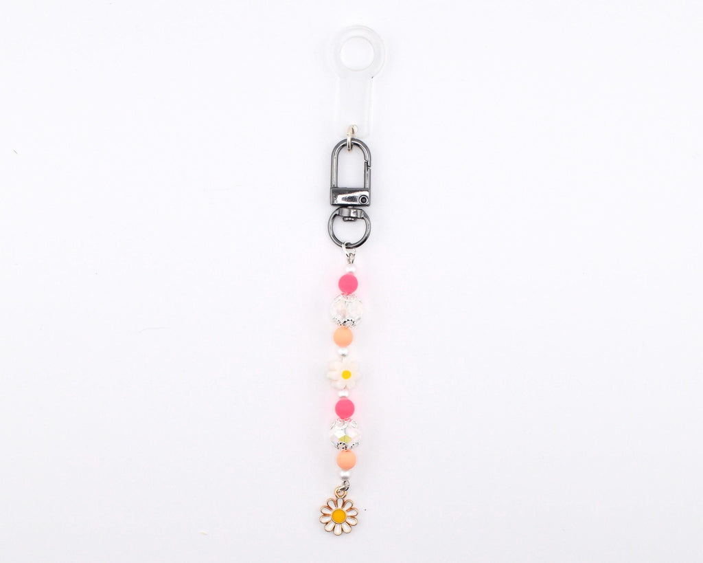 A beaded keychain featuring a silver-toned lobster clasp and a clear plastic loop. The strand includes alternating pink, peach, and white spherical beads, along with two white flower-shaped beads and a small white daisy charm at the end.