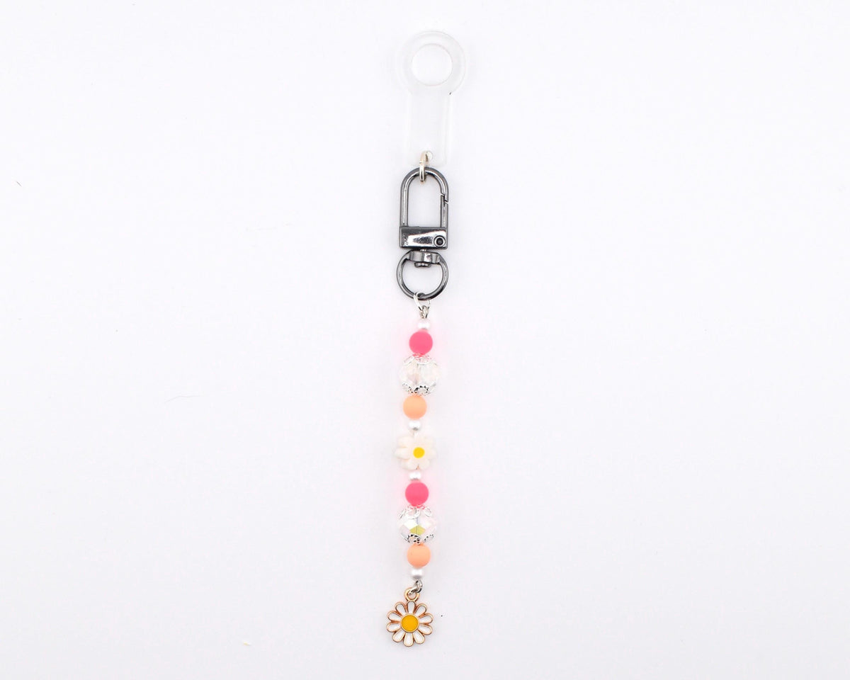 A beaded keychain featuring a silver-toned lobster clasp and a clear plastic loop. The strand includes alternating pink, peach, and white spherical beads, along with two white flower-shaped beads and a small white daisy charm at the end.