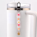 A beaded charm accessory featuring a silver-toned lobster clasp, pink and orange spherical beads, clear faceted beads, small white pearls, a white flower-shaped bead, and a gold-toned metal daisy charm with a yellow center.