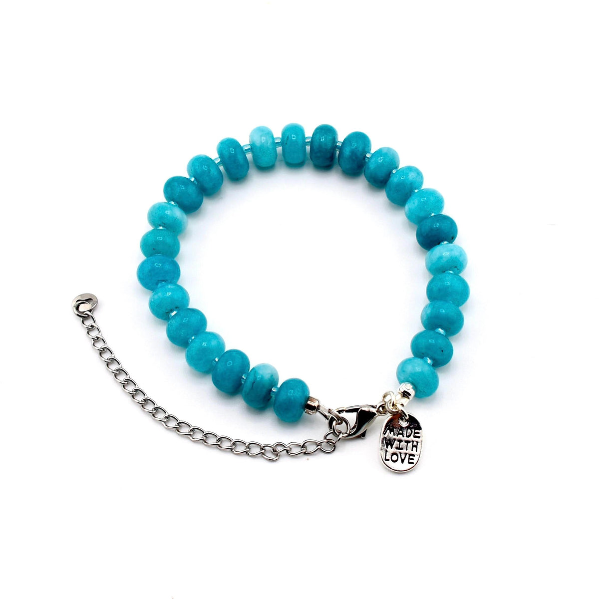 A bracelet featuring round, turquoise-colored beads strung together. It includes a silver-toned metal chain extender and a lobster claw clasp. A small, oval-shaped silver metal charm is attached, engraved with the text MADE WITH LOVE.