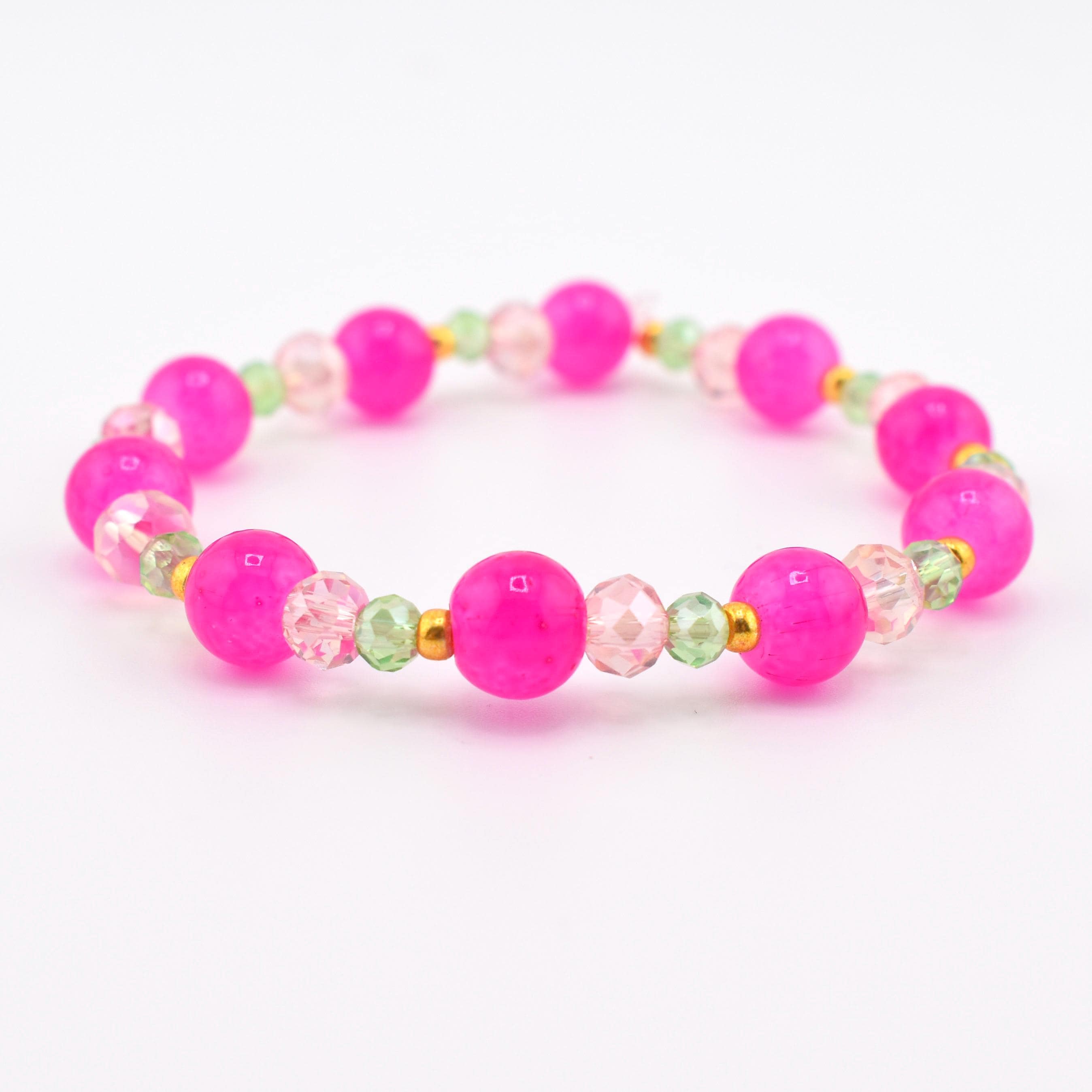 A beaded stretch bracelet featuring large, round, opaque hot pink beads alternating with smaller, faceted, translucent light pink and pale green beads, accented by tiny gold-toned metal spacers throughout the circular design.