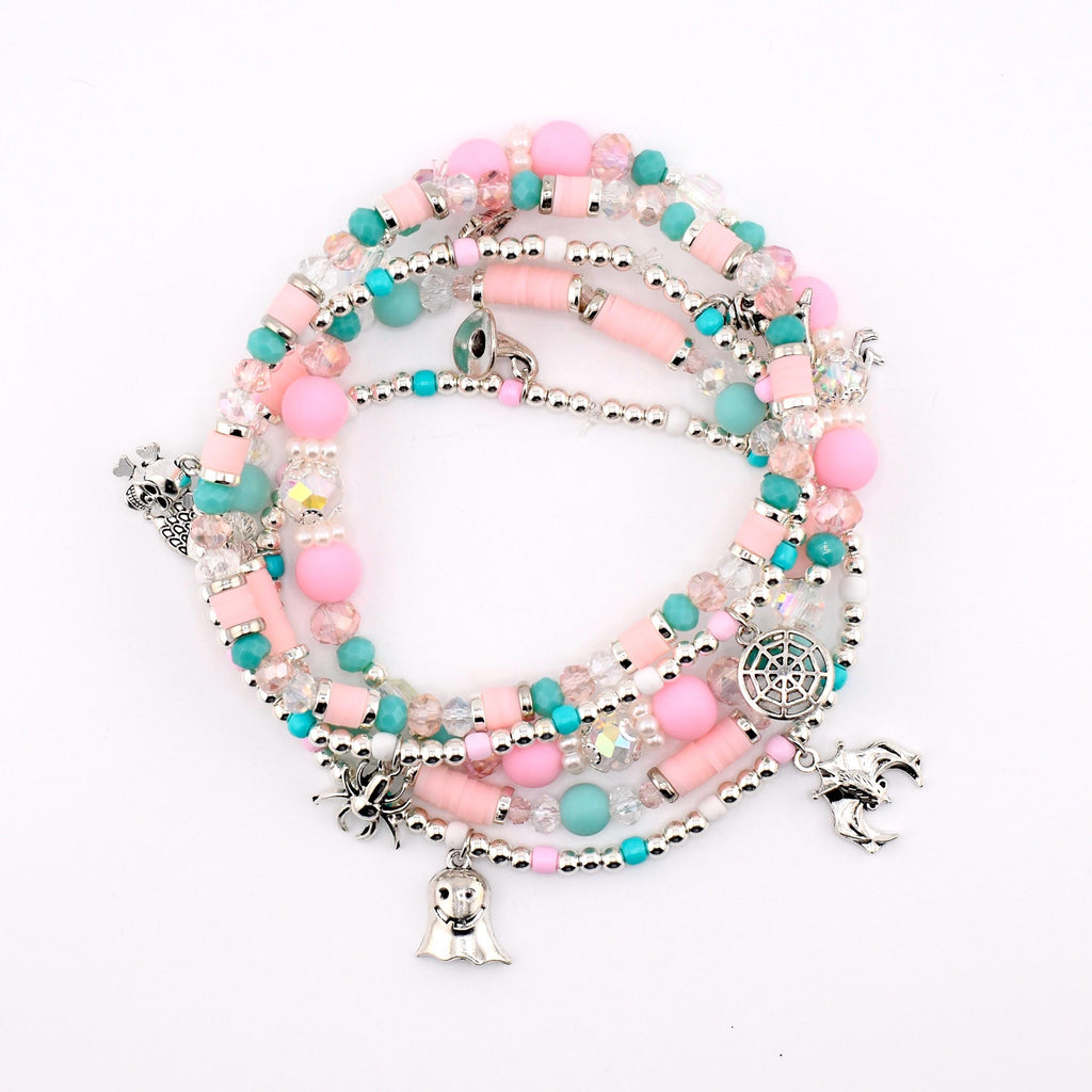 A multi-strand beaded bracelet featuring pink and turquoise beads, clear faceted crystals, and silver-toned charms including a spider, a ghost, a spiderweb, and a bat. The bracelet is constructed with various bead shapes and sizes.