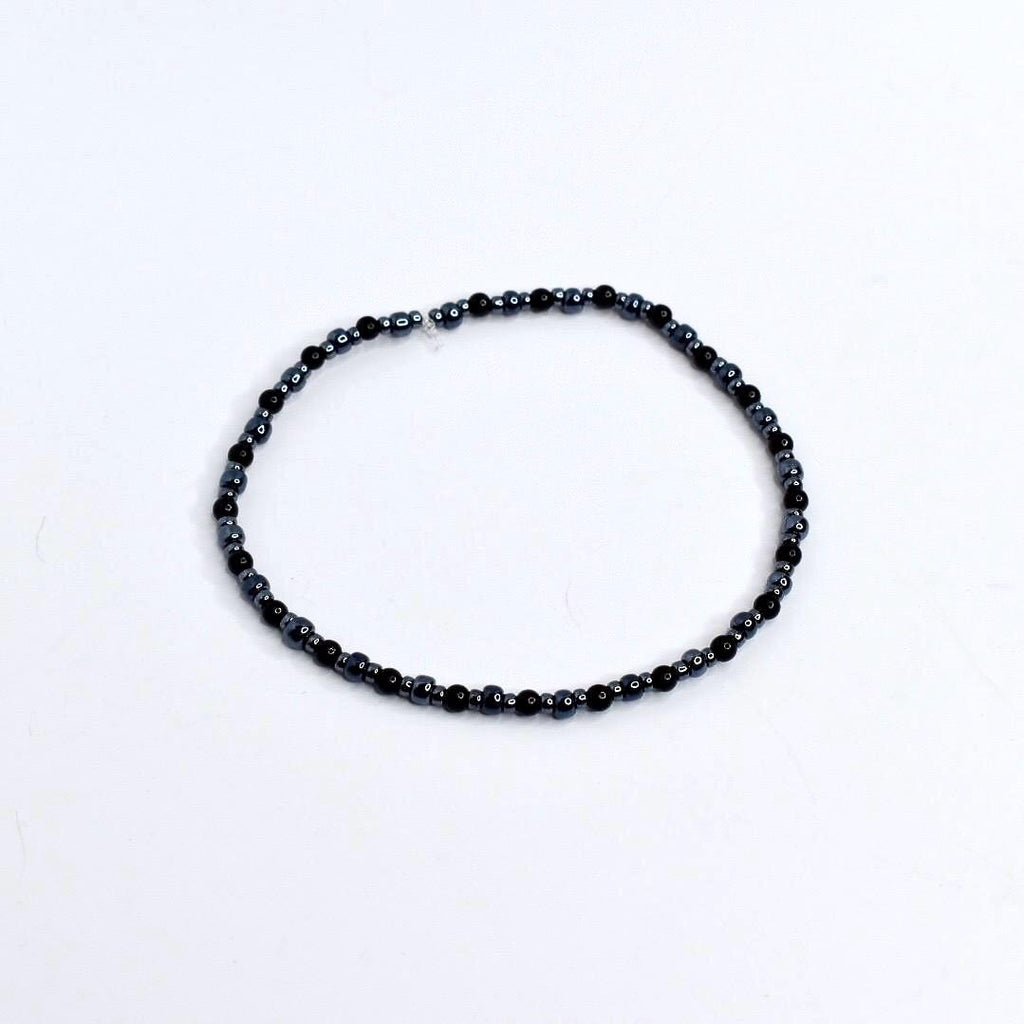 Beaded tumbler bracelet with spider, skeleton hand, and web charms – black and silver Halloween wrap bracelet for gothic drinkware decor.