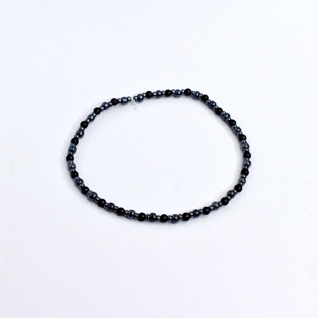 Beaded tumbler bracelet with spider, skeleton hand, and web charms – black and silver Halloween wrap bracelet for gothic drinkware decor.